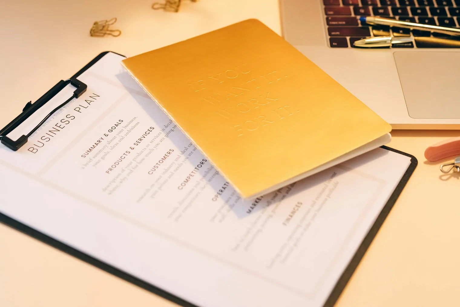 Career change planning documents and laptop used to map old experience to a new role