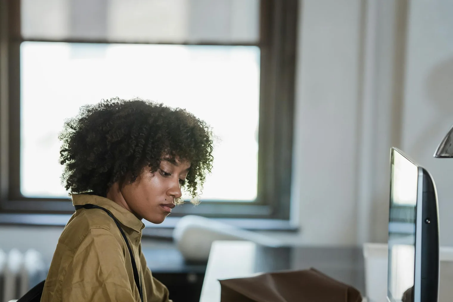 Career changer reviewing notes at a computer before rewriting resume bullets for a new role