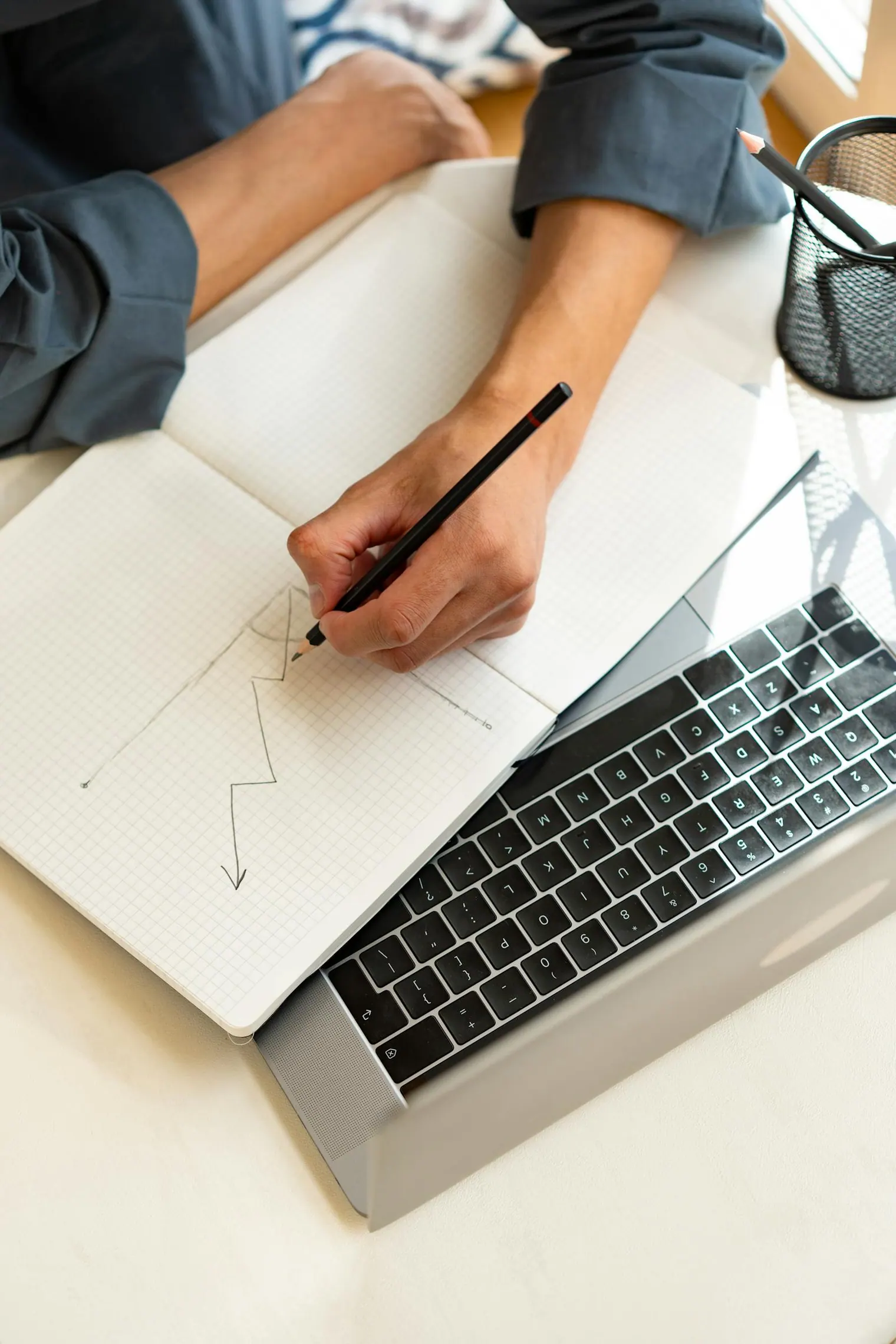 Interview feedback rubric sketched in a notebook beside a laptop for the next practice drill