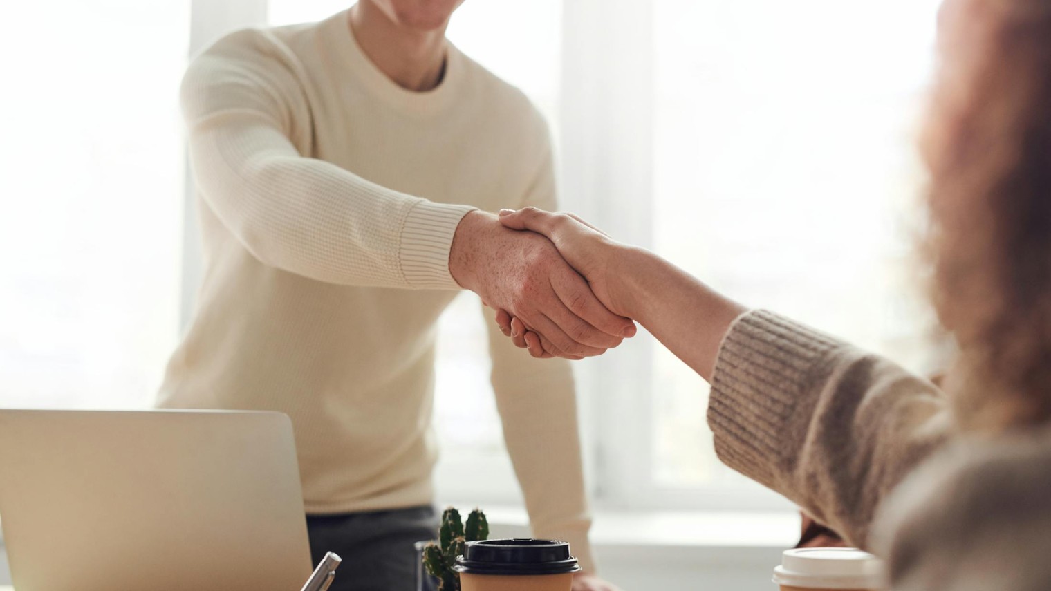 Candidate and interviewer shaking hands after discussing strengths and areas of improvement examples