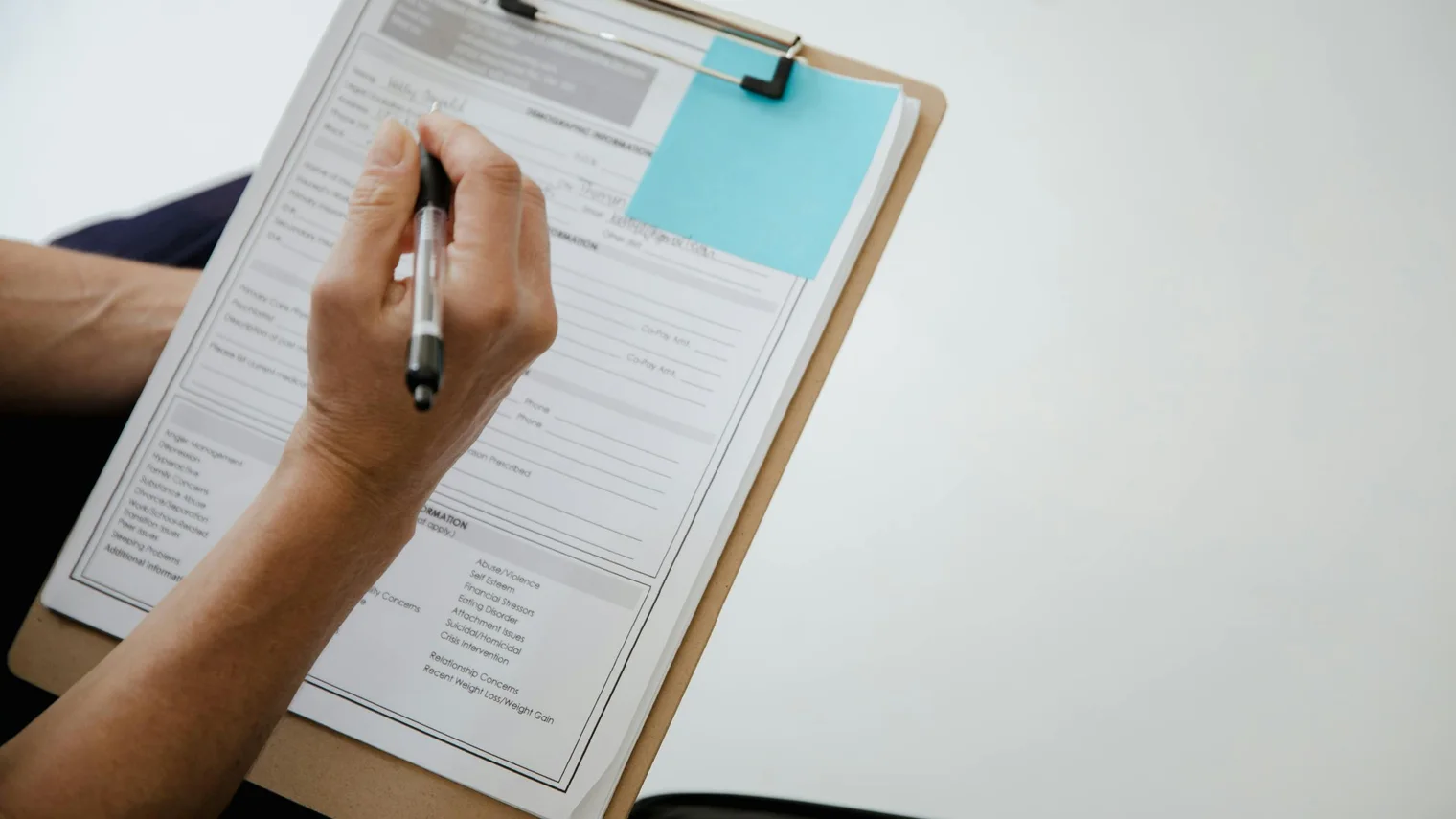 Job description keyword scorecard with resume notes on a clipboard and a blue sticky note