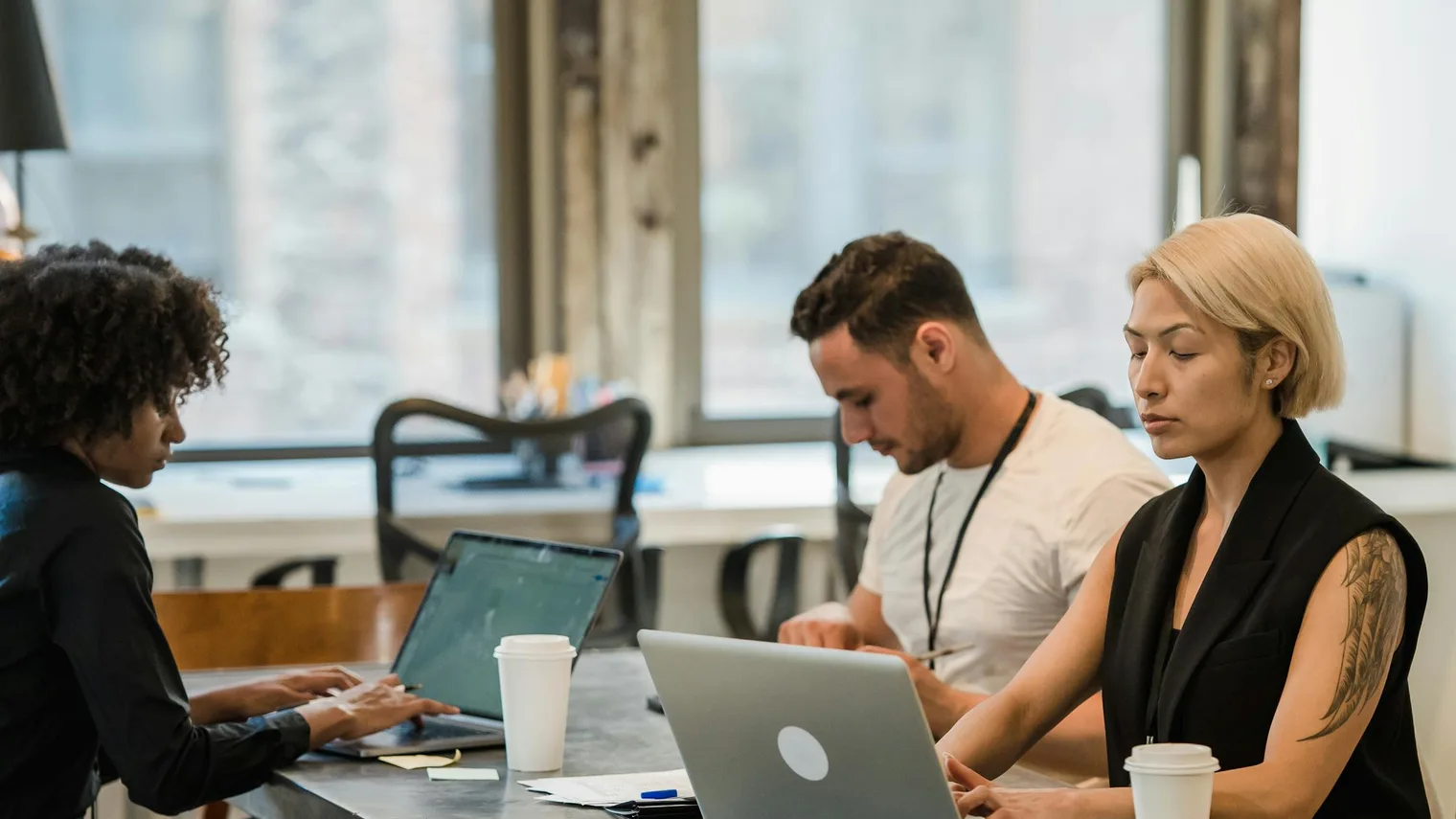 Professionals reviewing notes on laptops after a panel interview practice session
