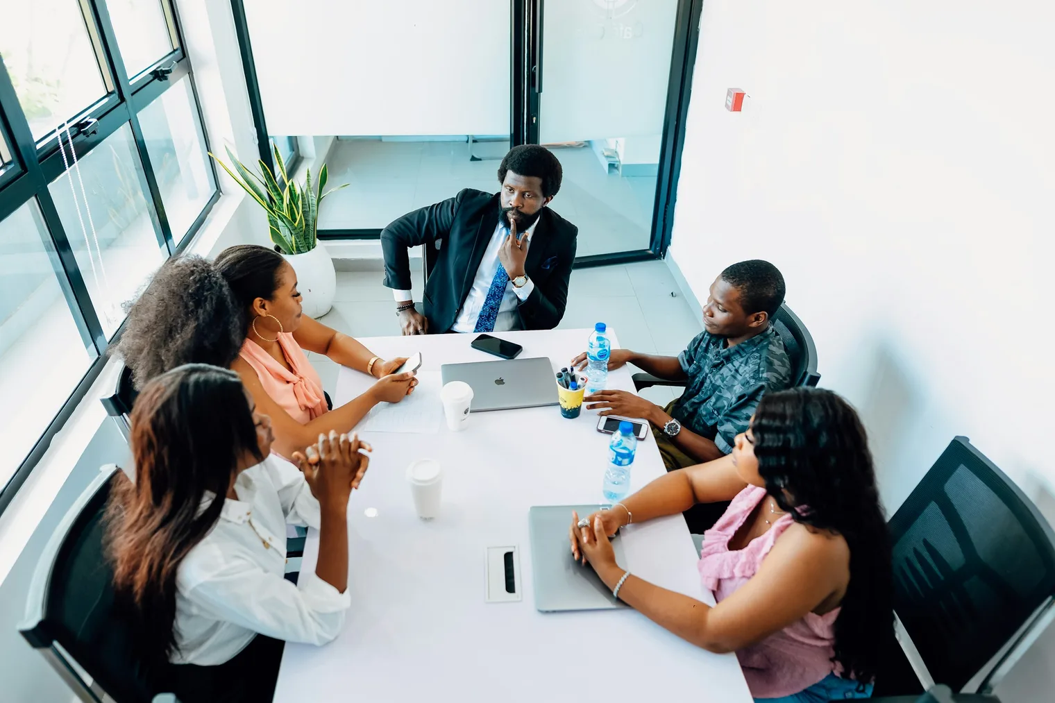 People manager leading a team discussion around a table before choosing leadership interview stories